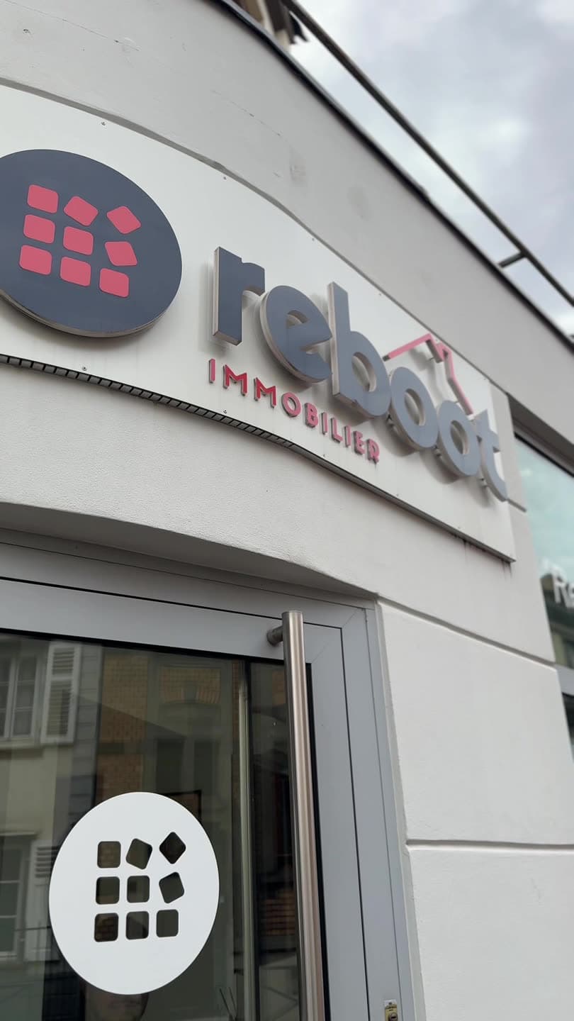 La façade de l'agence Reboot Immobilier, enseigne blanche sur pignon clair