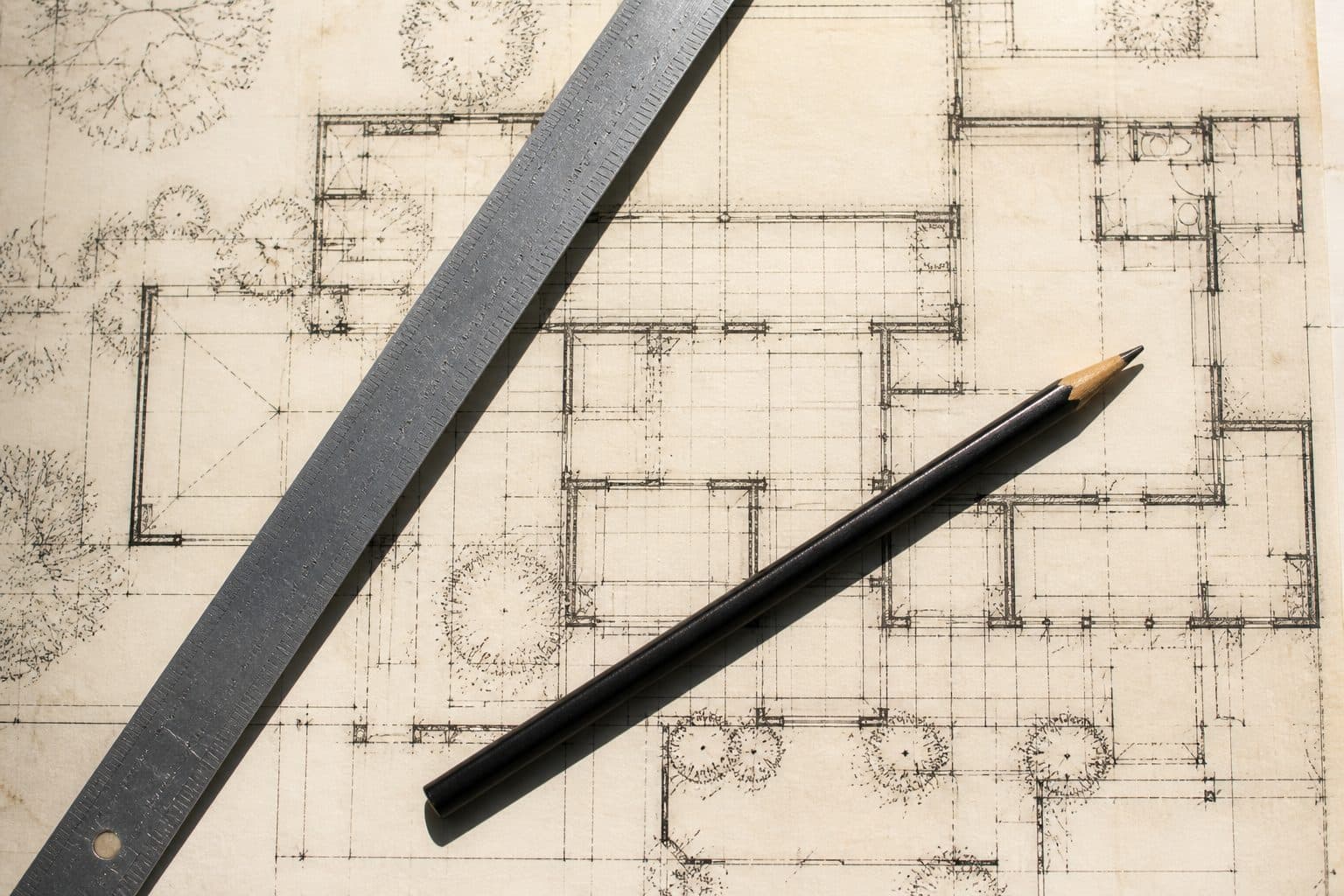 Un plan d'architecte vu du dessus, avec une règle et un crayon.